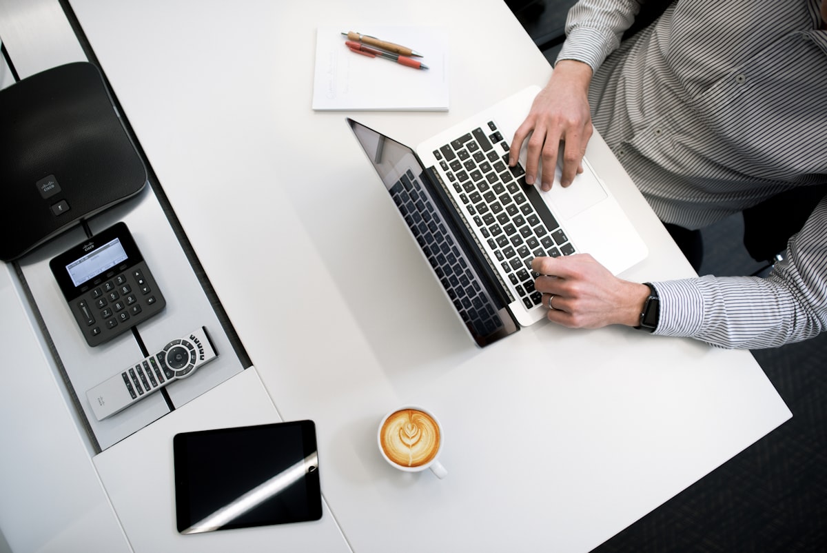 Business owner working at a clean desk with laptop and office tools